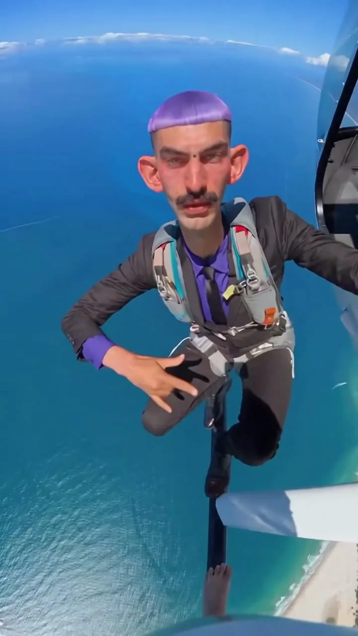 C free-falling over the ocean with a parachute harness