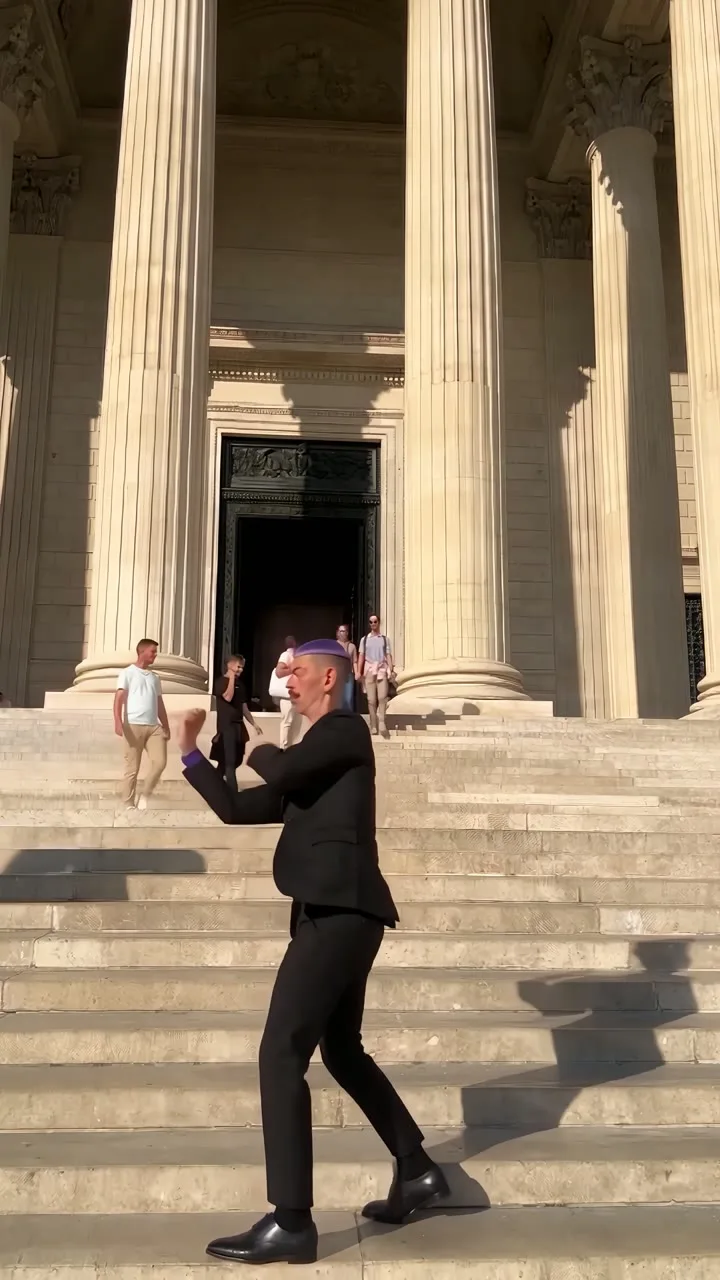 C dancing on the steps of a neoclassical building